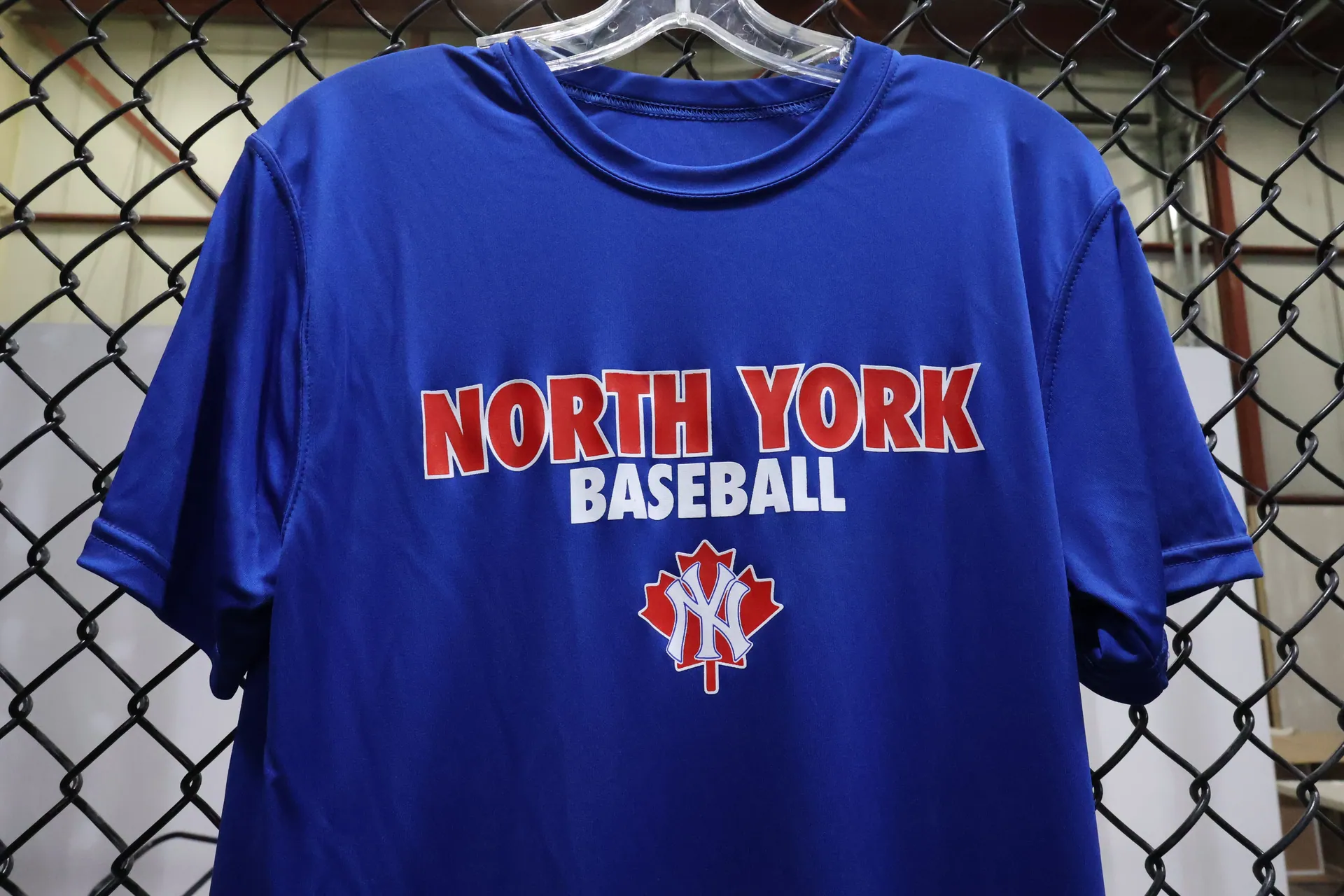 Blue North York Baseball shirt hanging at The Launch Pad